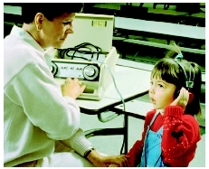 Technician testing a young girls hearing with an audiometer. (Photograph by Jon Meyer. Custom Medical Stock Photo, Inc.)