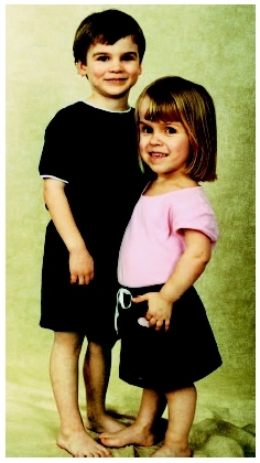 Young female dwarf standing next to a boy of normal stature. (Photograph by Dr. Richard Pauli. U. of Wisconsin, Madison, Clinical Genetics Center.)