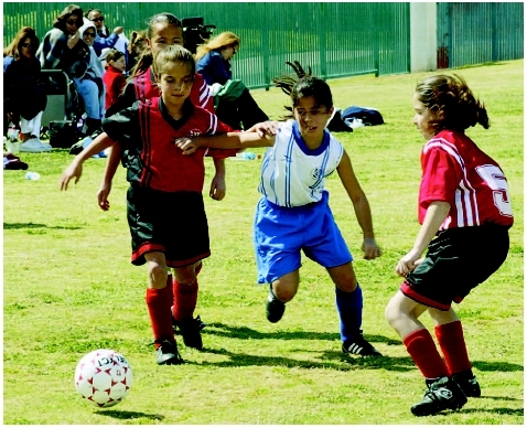 Girls using their gross motor skills, large muscle movements, to play soccer. (Photograph by Tony Freeman. PhotoEdit.)