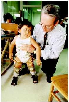 Doctor examining a child with spinal bifida. ( Annie Griffiths Belt/Corbis.)